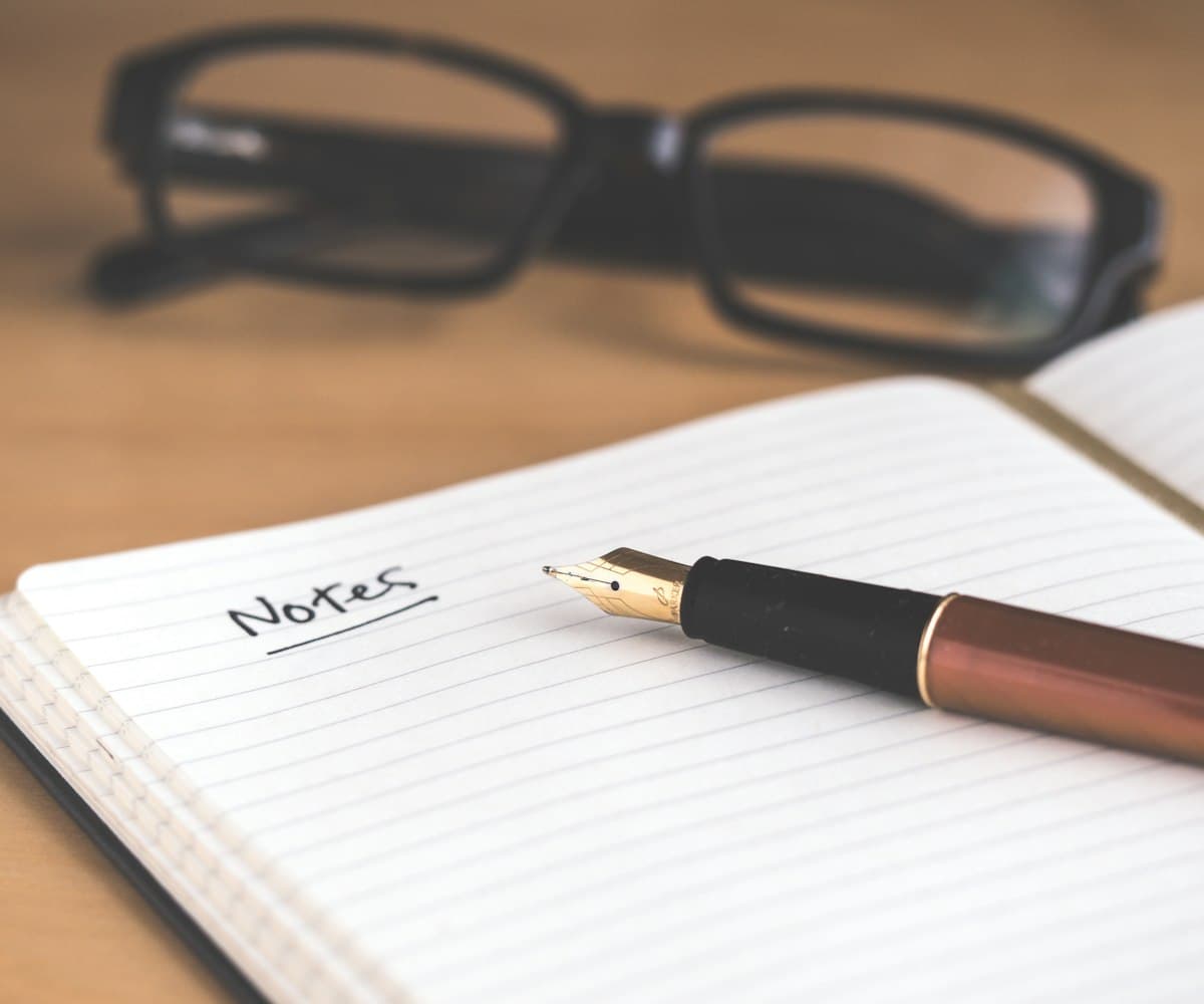 A notebook and fountain pen on a desk